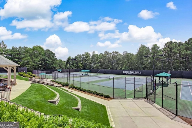 view of sport court featuring a yard and fence