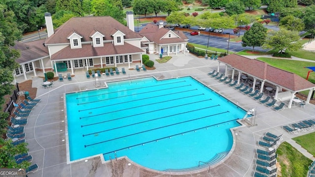 community pool with fence and a patio area