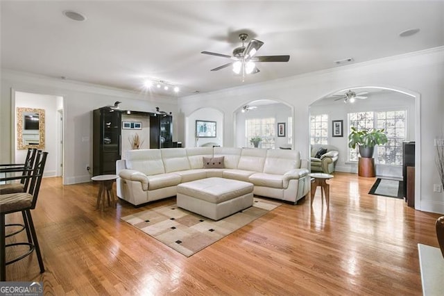 living room featuring ornamental molding, ceiling fan, and light hardwood / wood-style floors