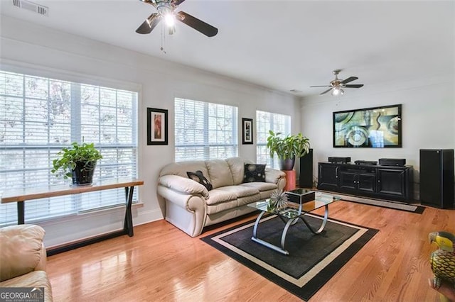 living room featuring a wealth of natural light, wood-type flooring, and ceiling fan