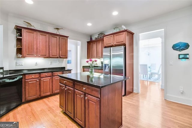 kitchen featuring light hardwood / wood-style floors, ornamental molding, a kitchen island, stainless steel fridge, and black dishwasher