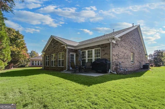 back of property with a lawn, central AC, and a patio area