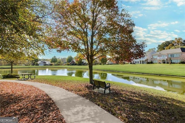 surrounding community featuring a lawn and a water view