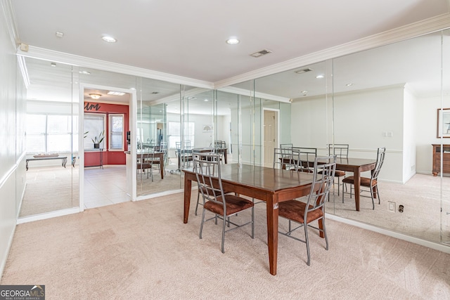 carpeted dining area with ornamental molding