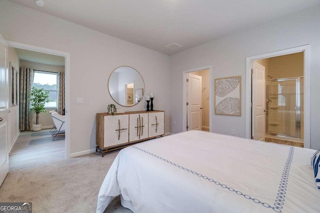 bedroom with light colored carpet and ensuite bathroom