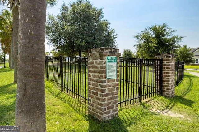 view of gate with a lawn