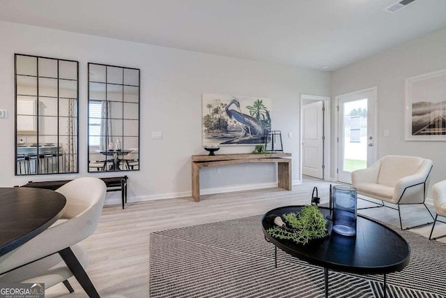 living room featuring plenty of natural light and light hardwood / wood-style flooring