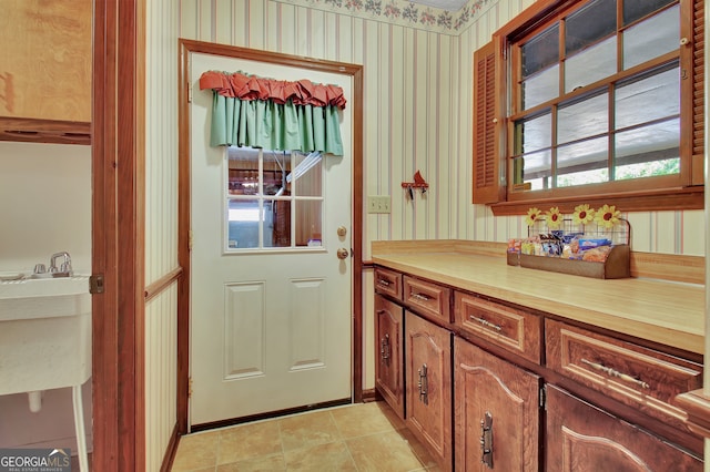 doorway featuring light tile patterned flooring and sink