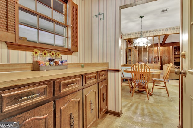 kitchen with wood counters, a chandelier, and pendant lighting