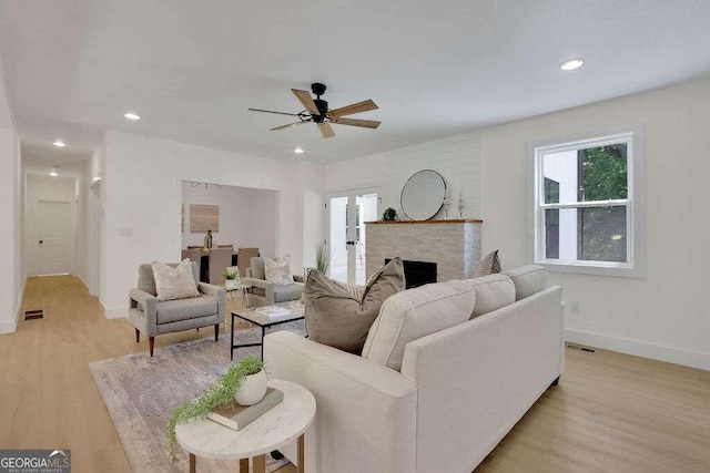 living room with light wood-type flooring and ceiling fan