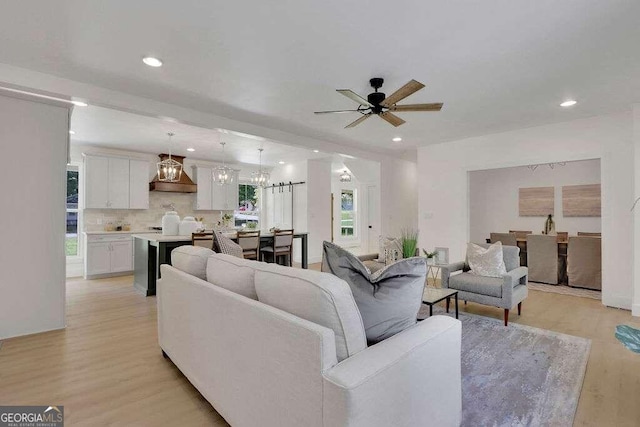 living room featuring ceiling fan and light hardwood / wood-style flooring