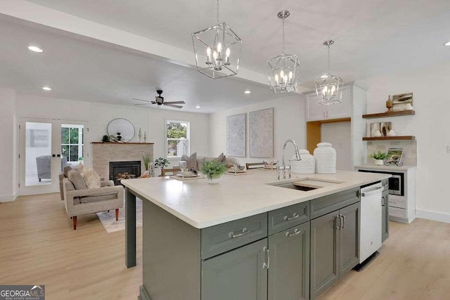 kitchen with an island with sink, a wealth of natural light, sink, and white dishwasher