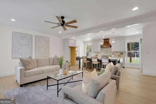 living room featuring ceiling fan and light hardwood / wood-style floors