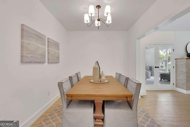 dining area with french doors, wood-type flooring, and a chandelier