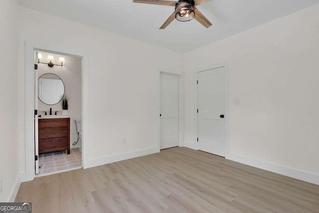 unfurnished bedroom featuring light hardwood / wood-style floors, ceiling fan, and connected bathroom