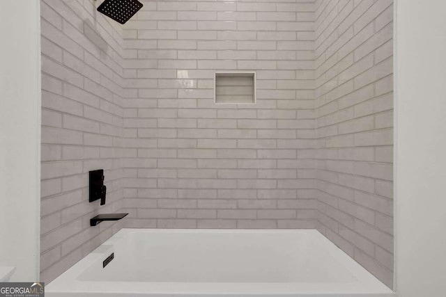 bathroom featuring tiled shower / bath