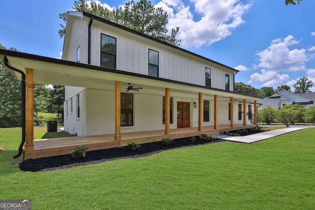 rear view of property with ceiling fan, a yard, and a porch