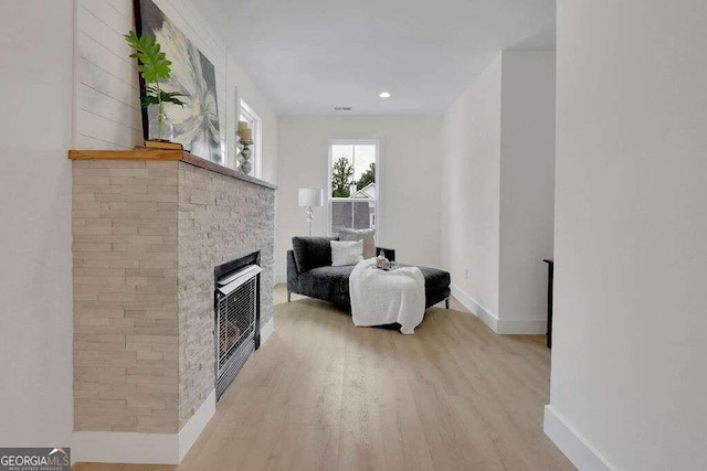 interior space featuring a stone fireplace and light wood-type flooring