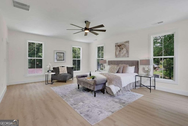 bedroom featuring light hardwood / wood-style flooring, multiple windows, and ceiling fan