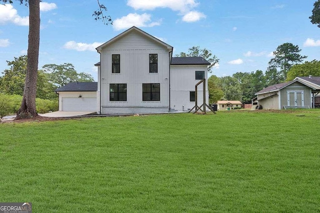 rear view of house featuring a garage and a lawn