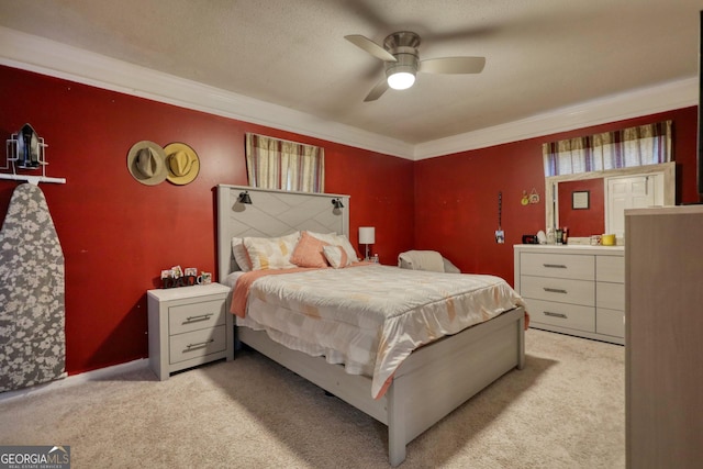 carpeted bedroom featuring ceiling fan and crown molding