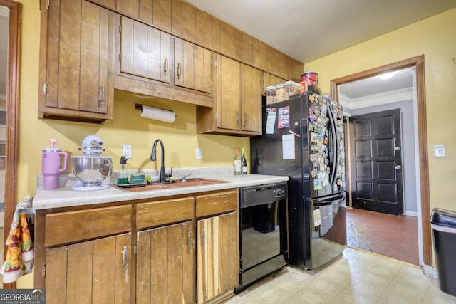 kitchen featuring black appliances, ornamental molding, and sink