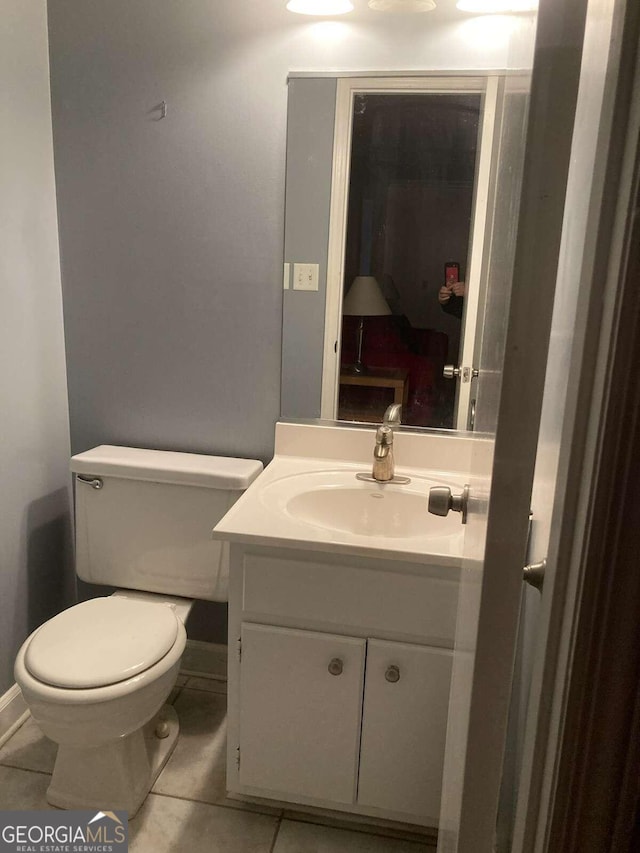 bathroom featuring toilet, vanity, and tile patterned floors