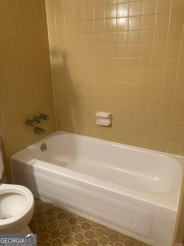 bathroom with tiled shower / bath and toilet