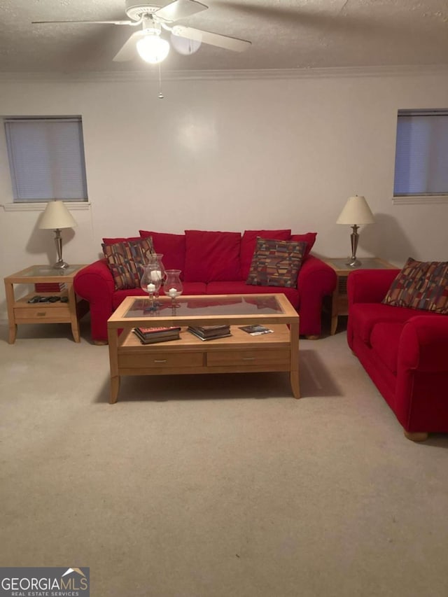 carpeted living room featuring a textured ceiling, ceiling fan, and crown molding