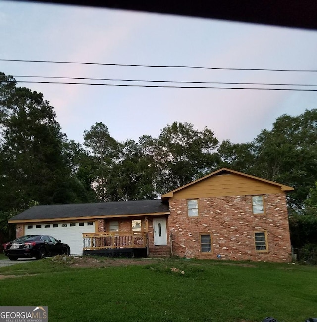 tri-level home featuring a front lawn and a garage