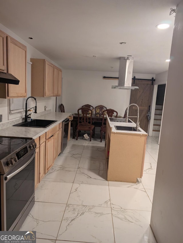 kitchen with stainless steel appliances, extractor fan, sink, light brown cabinets, and a barn door