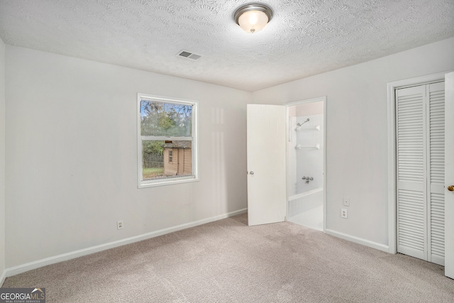 unfurnished bedroom featuring carpet flooring and a textured ceiling