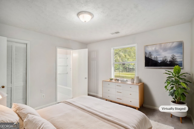 carpeted bedroom featuring a textured ceiling