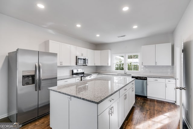 unfurnished room with baseboards, visible vents, and wood finished floors