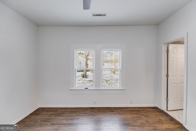 spare room with plenty of natural light, ceiling fan, and dark wood-style floors