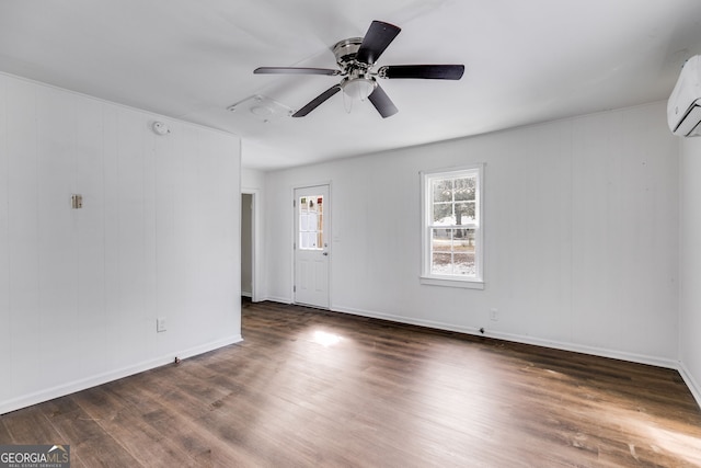 empty room with ceiling fan, dark hardwood / wood-style flooring, and a wall unit AC