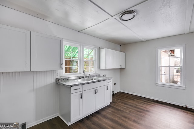 kitchen featuring dark wood-type flooring, white cabinetry, and sink