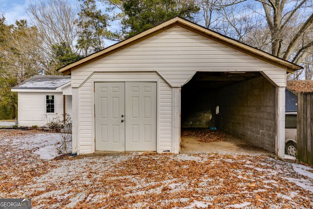 snow covered structure with a garage