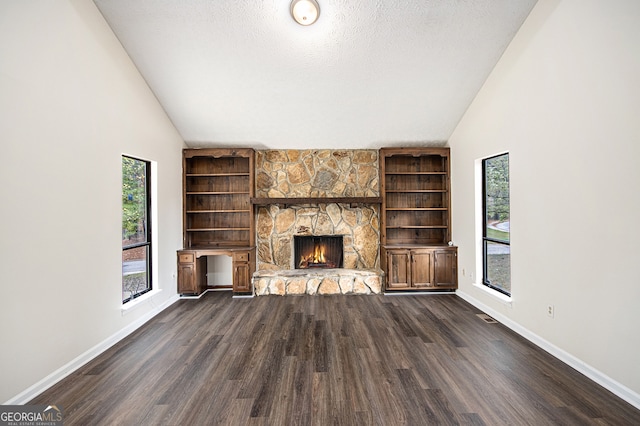 unfurnished living room with a stone fireplace, high vaulted ceiling, dark wood-type flooring, and a textured ceiling