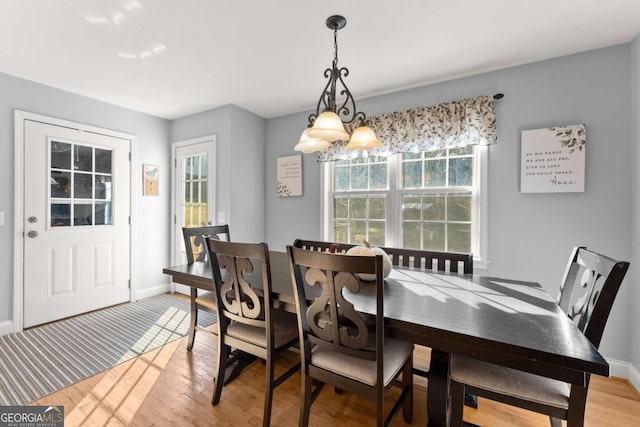 dining room with light hardwood / wood-style floors and a chandelier