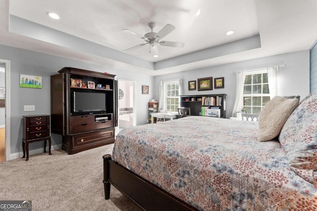 bedroom with ensuite bathroom, a tray ceiling, ceiling fan, and carpet floors