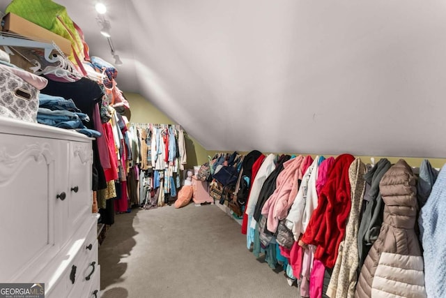 walk in closet with carpet and lofted ceiling