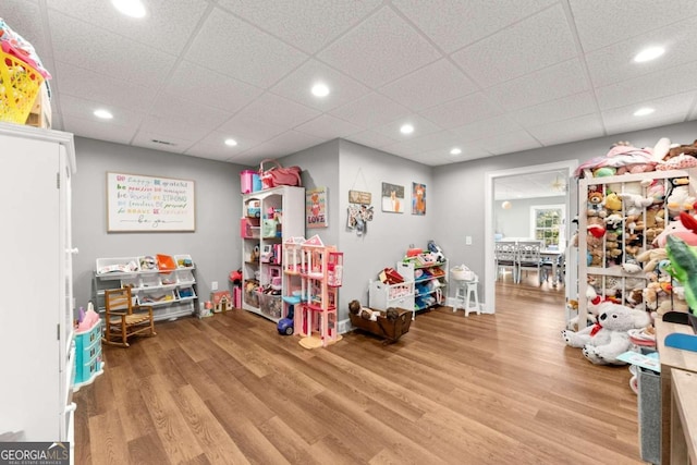 rec room with wood-type flooring and a paneled ceiling