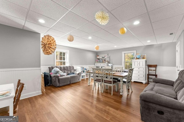 dining space with hardwood / wood-style floors and a paneled ceiling