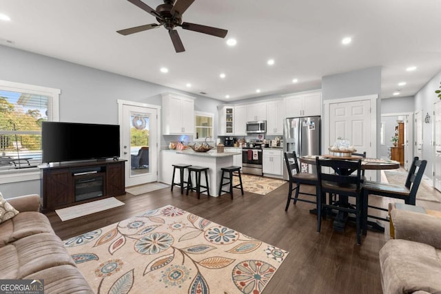 living room featuring ceiling fan and dark hardwood / wood-style floors