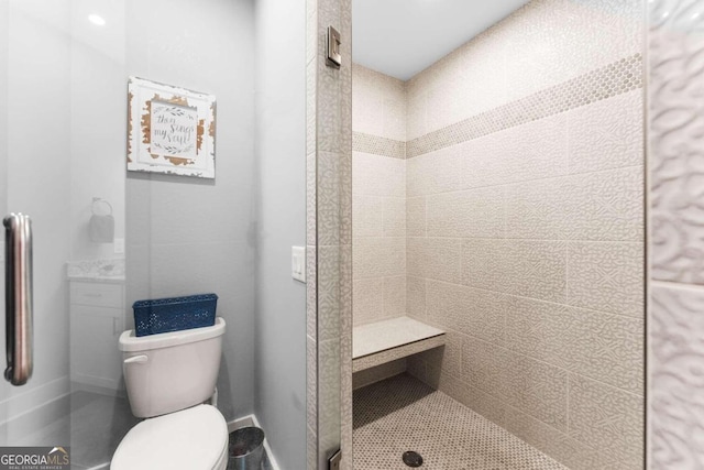 bathroom featuring toilet and tiled shower