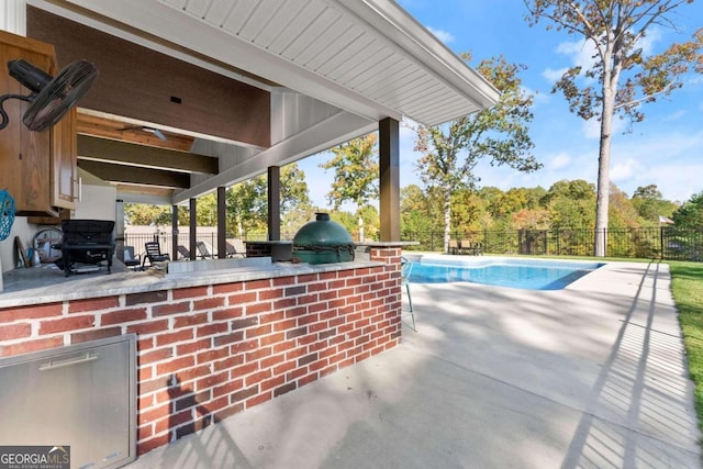 view of patio featuring grilling area, a fenced in pool, and exterior kitchen