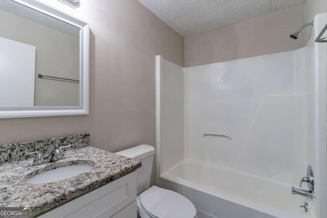 full bathroom featuring toilet, vanity, a textured ceiling, and  shower combination