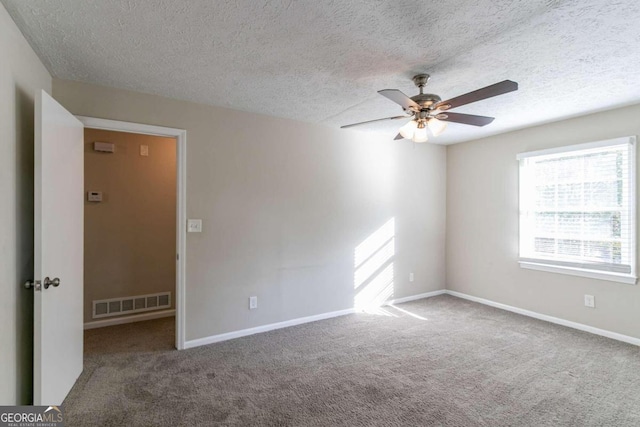 empty room with a textured ceiling, carpet floors, and ceiling fan