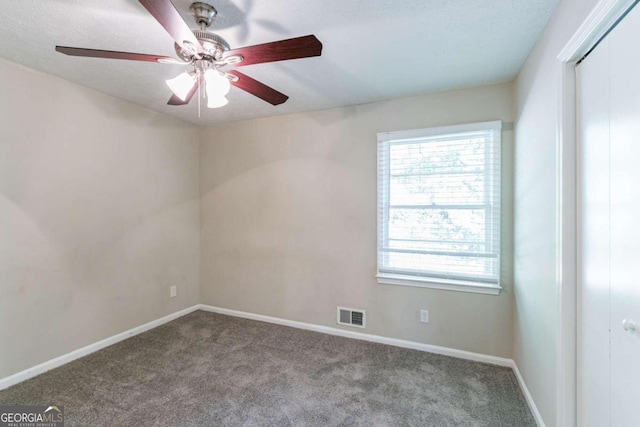 carpeted spare room featuring ceiling fan and a textured ceiling